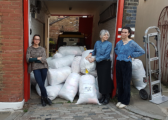 A picture of Knit for Peace staff waiting to load sacks of donated knitting to be sent to people in need.